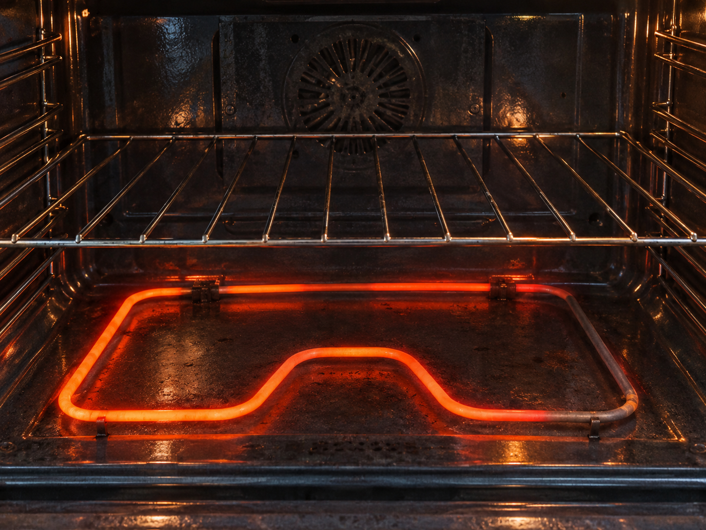 Electric oven bake element glowing unevenly with a dark section